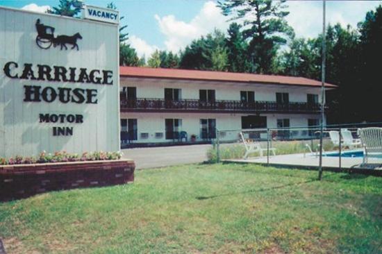 un panneau pour une remise devant un bâtiment dans l'établissement Carriage House Motor Inn, à Lake Placid