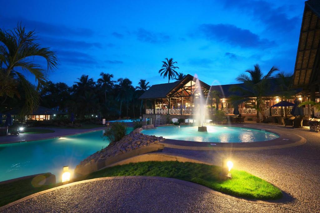 una fontana di fronte a un resort di notte di Labadi Beach Hotel a Accra