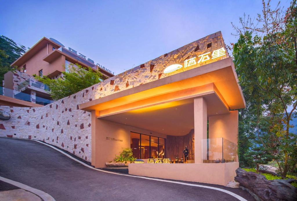 a building with a sign on the side of it at Zhangjiajie Shisuji Hotel (Zhangjiajie National Forest Park Sign Gate Branch) in Zhangjiajie