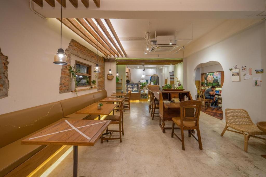 a restaurant with tables and chairs in a room at Need a Nap Hostel Phrae in Phrae