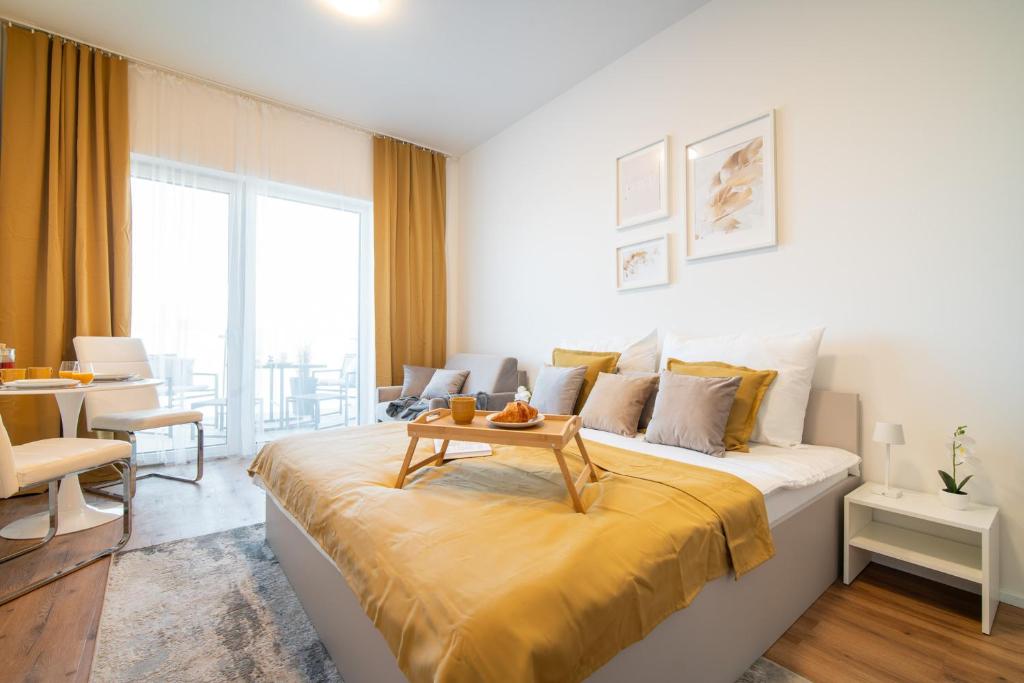 a bedroom with a bed with a table on it at apartino - FREE parking - Novostavba - Omezený přístup a stavební ruch - New Building - Limited Access and Construction noise in Komárov