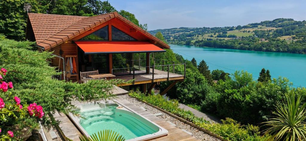 a house with a swimming pool next to a lake at SEEBLICK romantic chalet spa lake view in Paladru