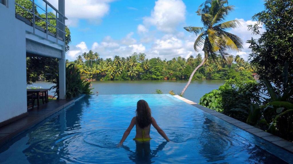 a woman in a infinity pool in a villa at 33 Lake Terrace in Hikkaduwa