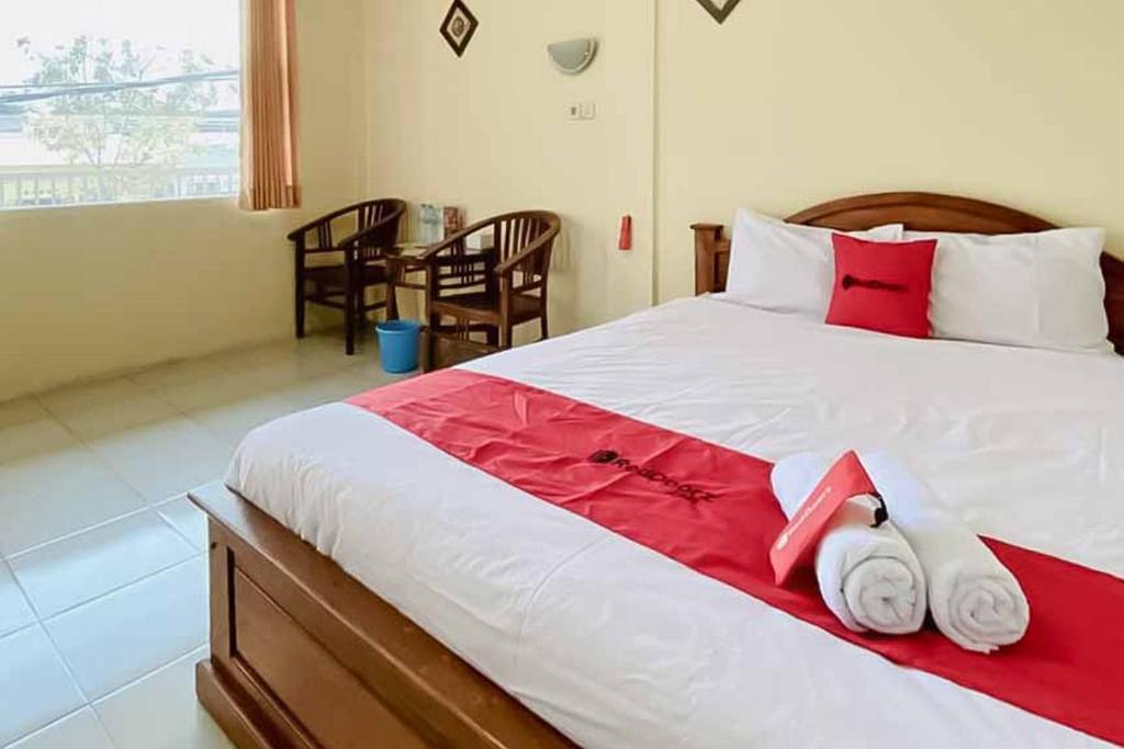 a bedroom with a large bed with towels on it at RedDoorz Syariah near T1 Juanda Airport 2 in Surabaya