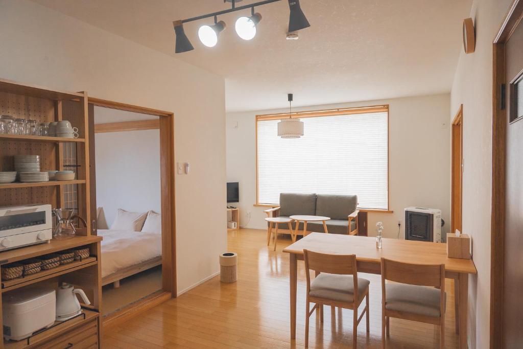una camera con tavolo da pranzo e una camera da letto di Mother River Stays -Stream Inn Shibetsu- Vacation Home, Gateway to Shiretoko & Nemuro Strait a Shibetsu