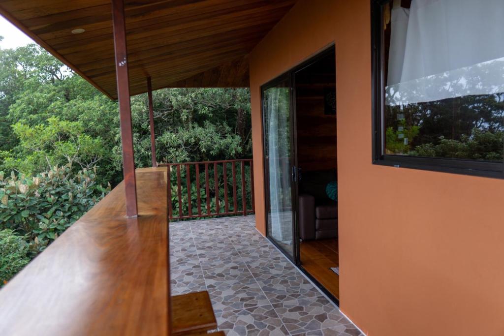 a house with a balcony with a view at Cabina vista al valle Monteverde in Monteverde Costa Rica