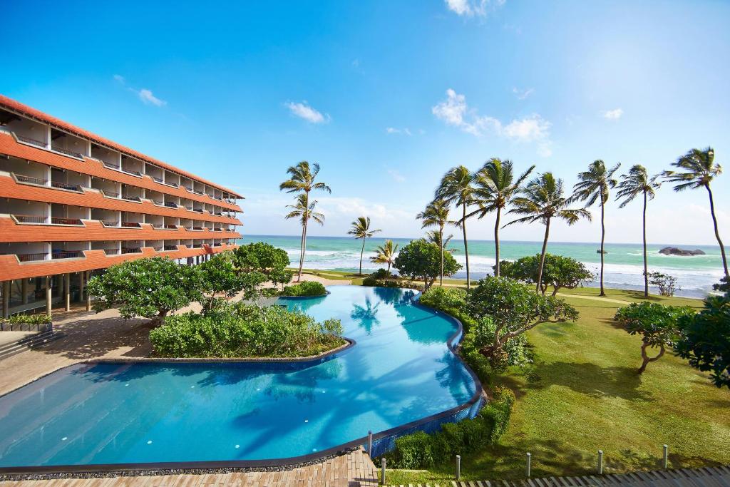 Una vista aérea de un complejo turístico con palmeras y piscina. en Hikka Tranz by Cinnamon, en Hikkaduwa