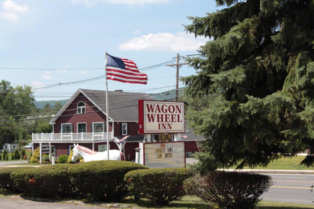 un panneau pour une auberge de wagons avec drapeau américain dans l'établissement Wagon Wheel Inn, à Lenox