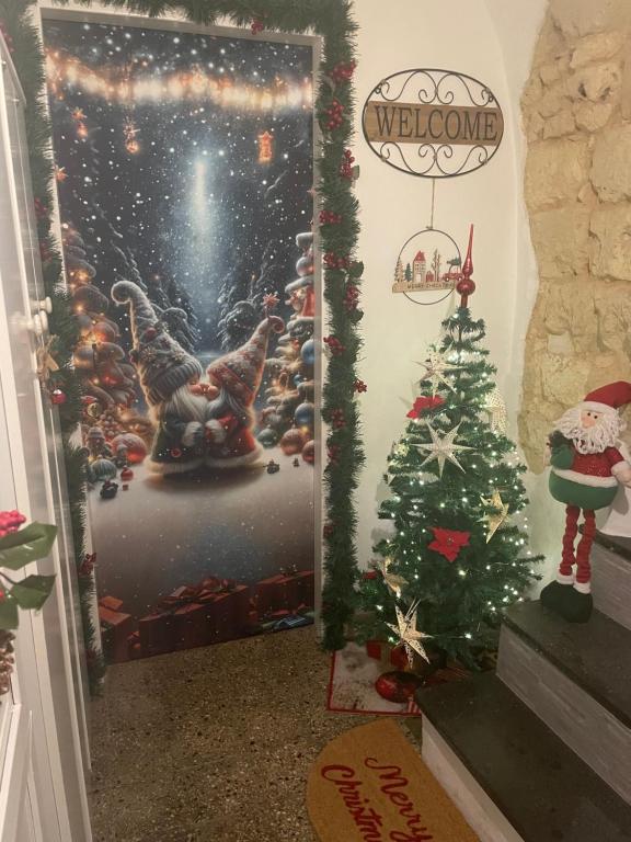サッサリにあるLa casa di Pi Taのクリスマスの看板とクリスマスツリーが飾られたドア