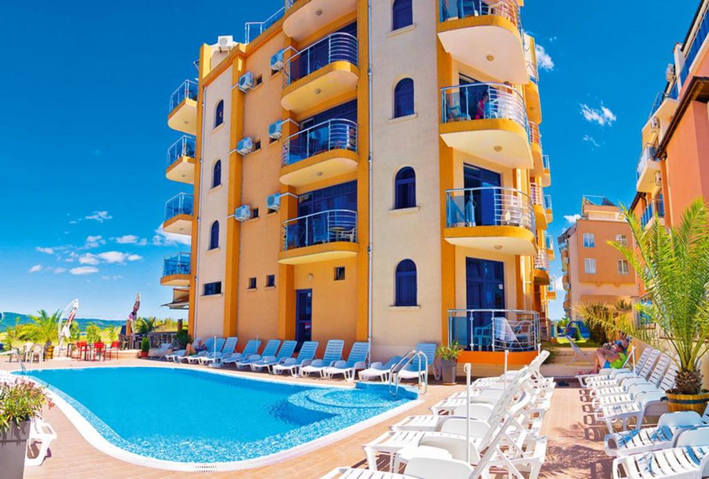 a hotel with a swimming pool in front of a building at Hotel Penelope in Primorsko