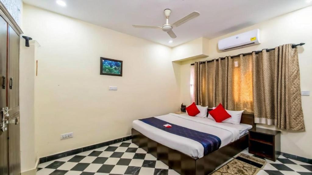 a bedroom with a bed with red pillows on it at PeaceWood in kolkata