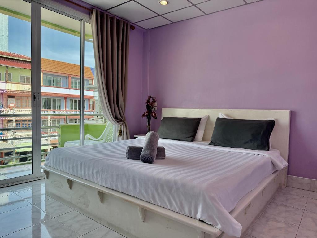 a bedroom with a large bed with purple walls at Baan Keang Talay Cha Am in Cha Am