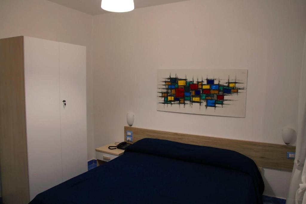 a bedroom with a bed and a painting on the wall at Belvedere in Procida