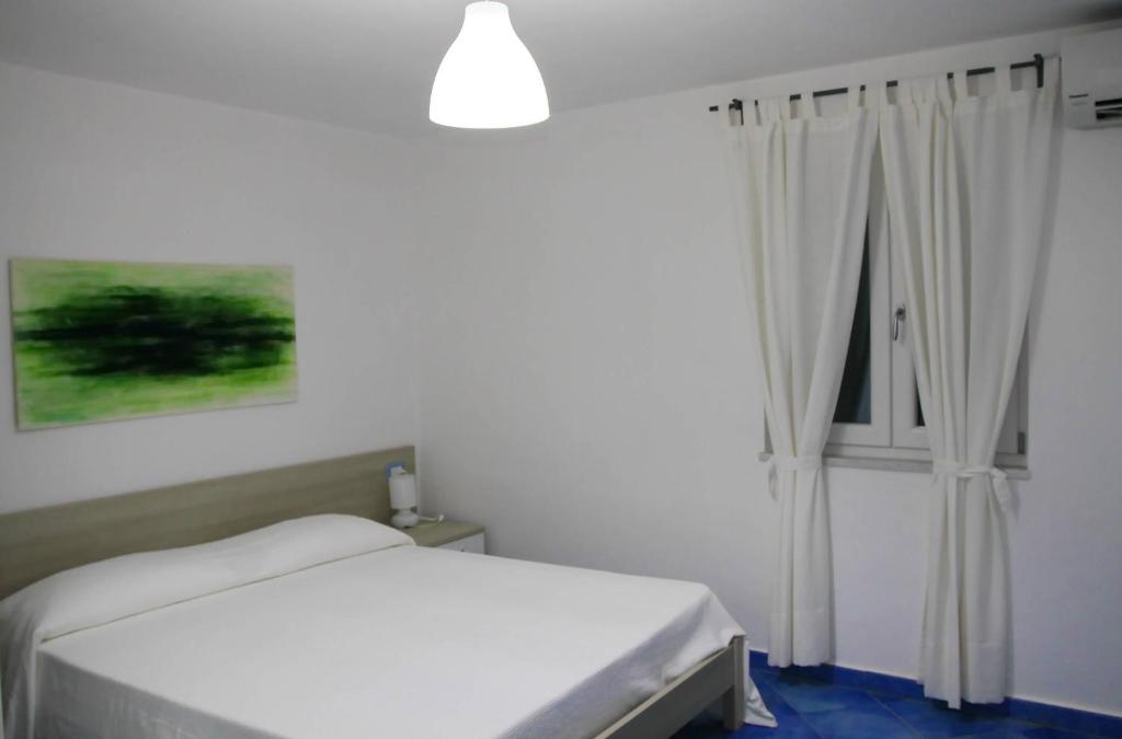 a bedroom with a white bed and a window at Belvedere in Procida