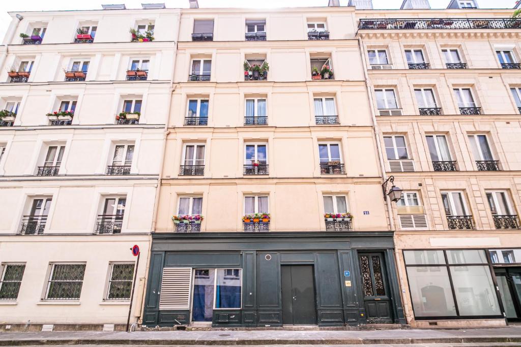 un gran edificio blanco con macetas. en WS Louvre - Saint-Germain, en París