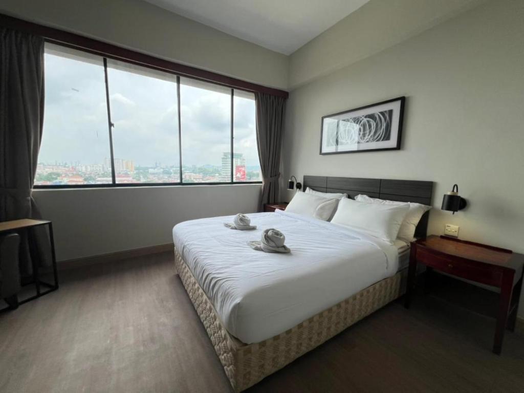 a hotel room with a large bed with a large window at Swing & Pillows - I-City, Shah Alam in Klang