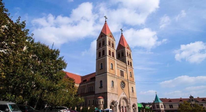 Un edificio con una torre con un orologio sopra di 7 Days Premium Qingdao Keji Street Taishan Road Metro Station a Qingdao