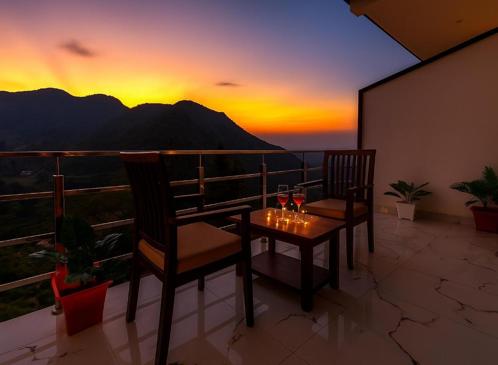 uma varanda com 2 cadeiras e uma mesa com copos de vinho em Hotel The SSB - ! luxury balcony rooms ! mountain view ! rooftop cafe ! big parking ! property of the year ! em Mussoorie