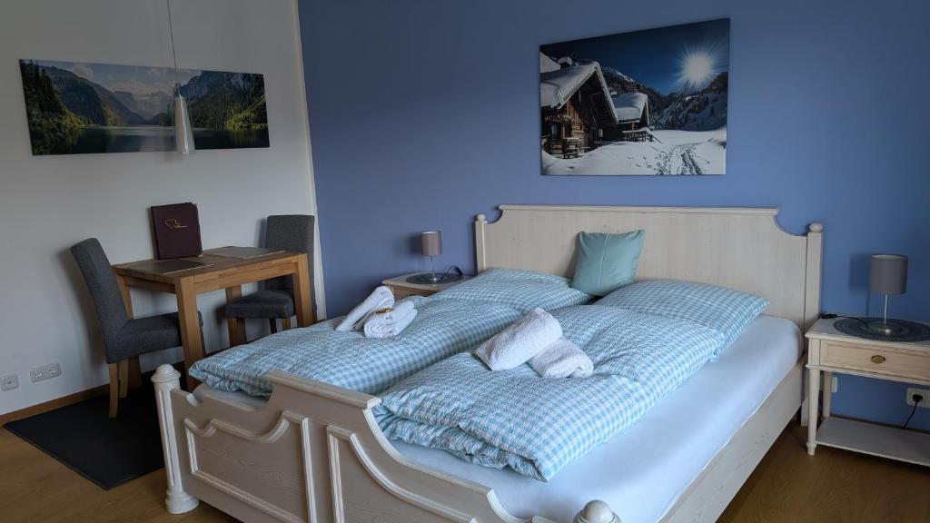 a bedroom with a bed with blue walls at Ferienwohnung Alpenglück in Bolsterlang Sommerbergbahn kostenlos in Bolsterlang