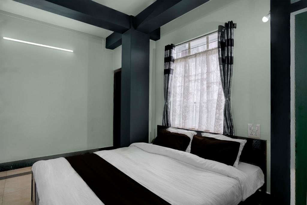 a bedroom with a bed and a window at Townhouse Howell Crossway Shillong Formerly Laban Guest House in Shillong
