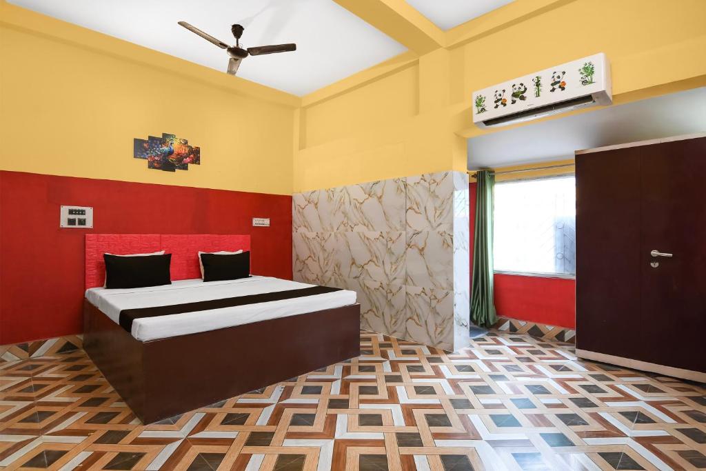 1 dormitorio con 1 cama con paredes rojas y amarillas en Hotel O Madhyamgram Railway Junction Formerly Dreamland, en Dohāri