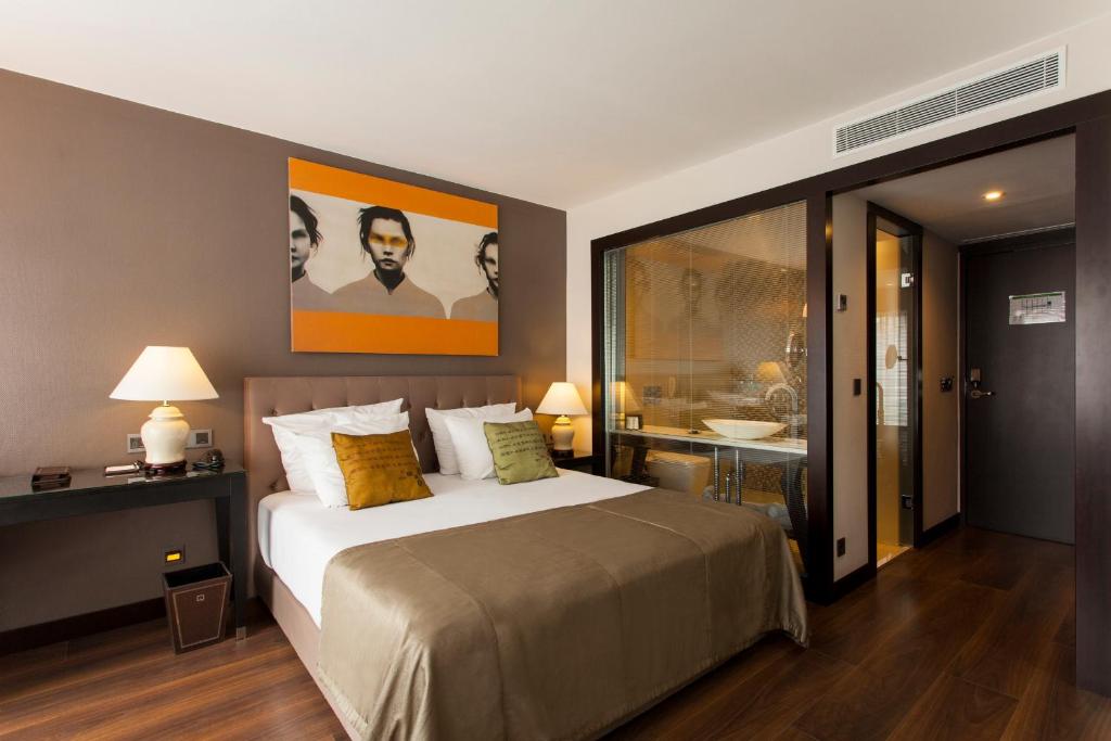 1 Schlafzimmer mit einem großen Bett und einem Badezimmer in der Unterkunft Quentin Berlin Hotel am Kurfürstendamm in Berlin