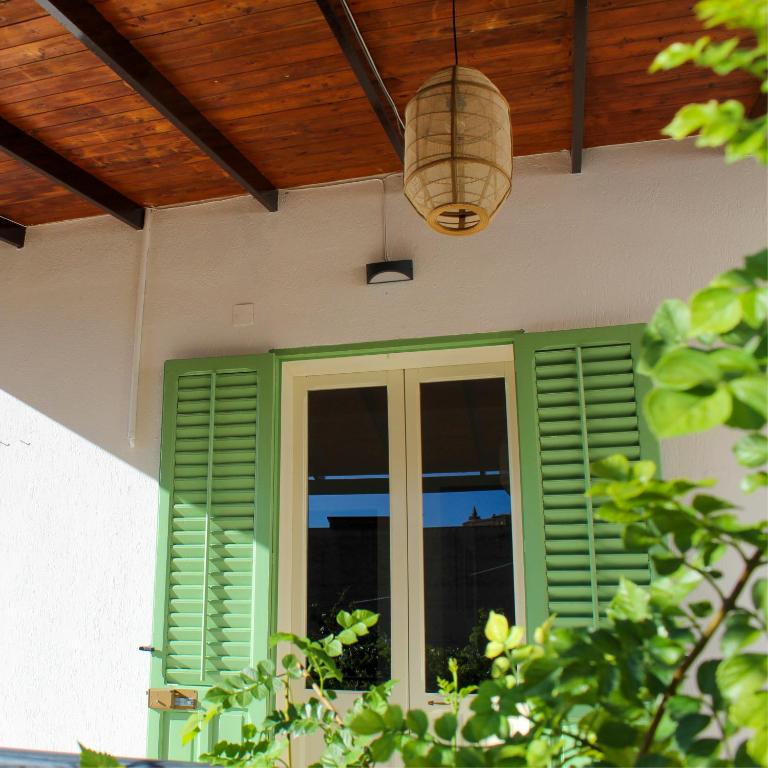 a porch with green shutters and a wooden ceiling at Villa Clara - Comfort e natura nel cuore di Sambuca in Sambuca di Sicilia