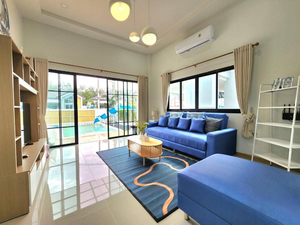 a living room with a blue couch and a table at Serene Poolvilla hatyai in Hat Yai
