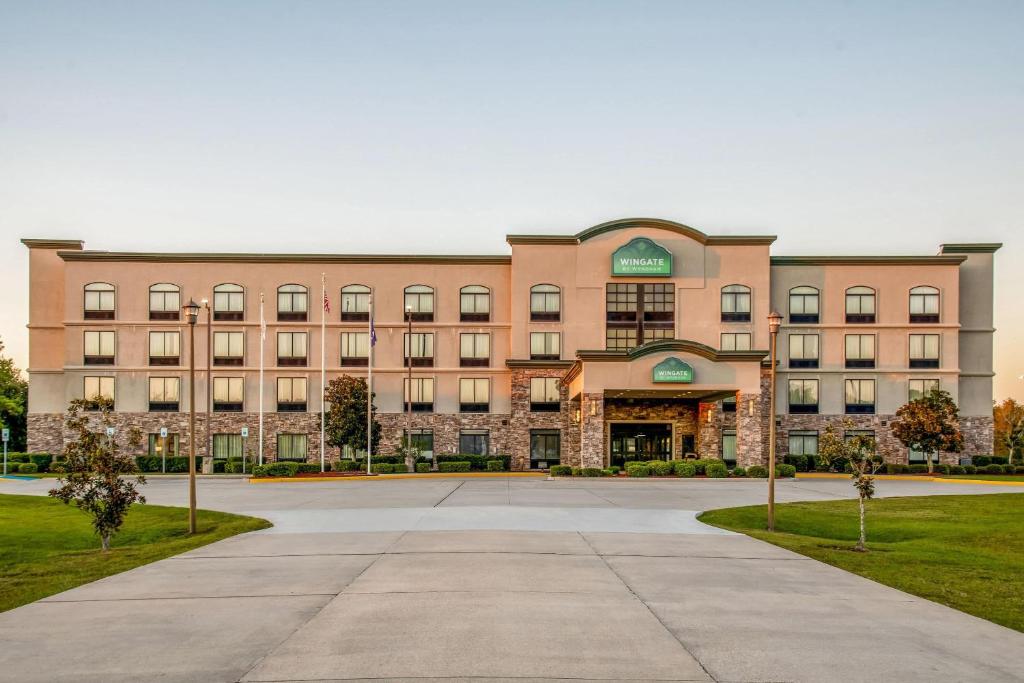a large brick building with a driveway in front of it at Wingate Slidell New Orleans in Slidell
