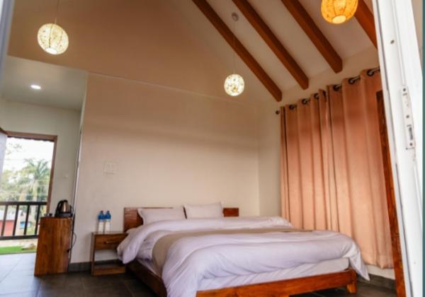 a bedroom with a large bed and a window at Hotel RaptiRiverview in Khargauli