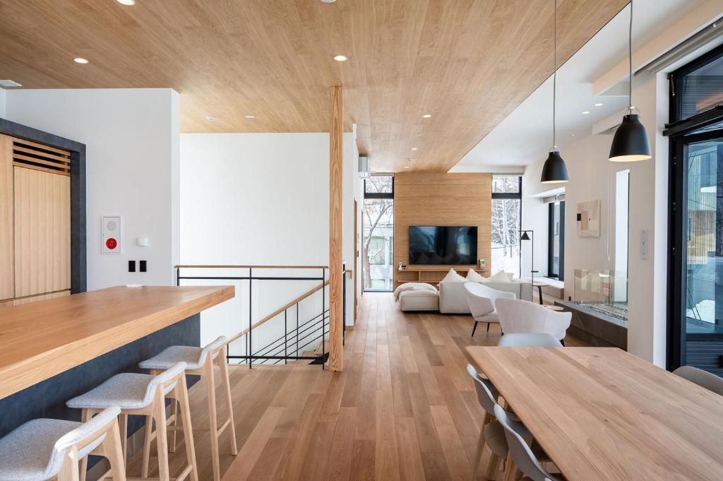 una sala da pranzo e un soggiorno con tavolo e sedie di V Residence by H2 Life a Niseko