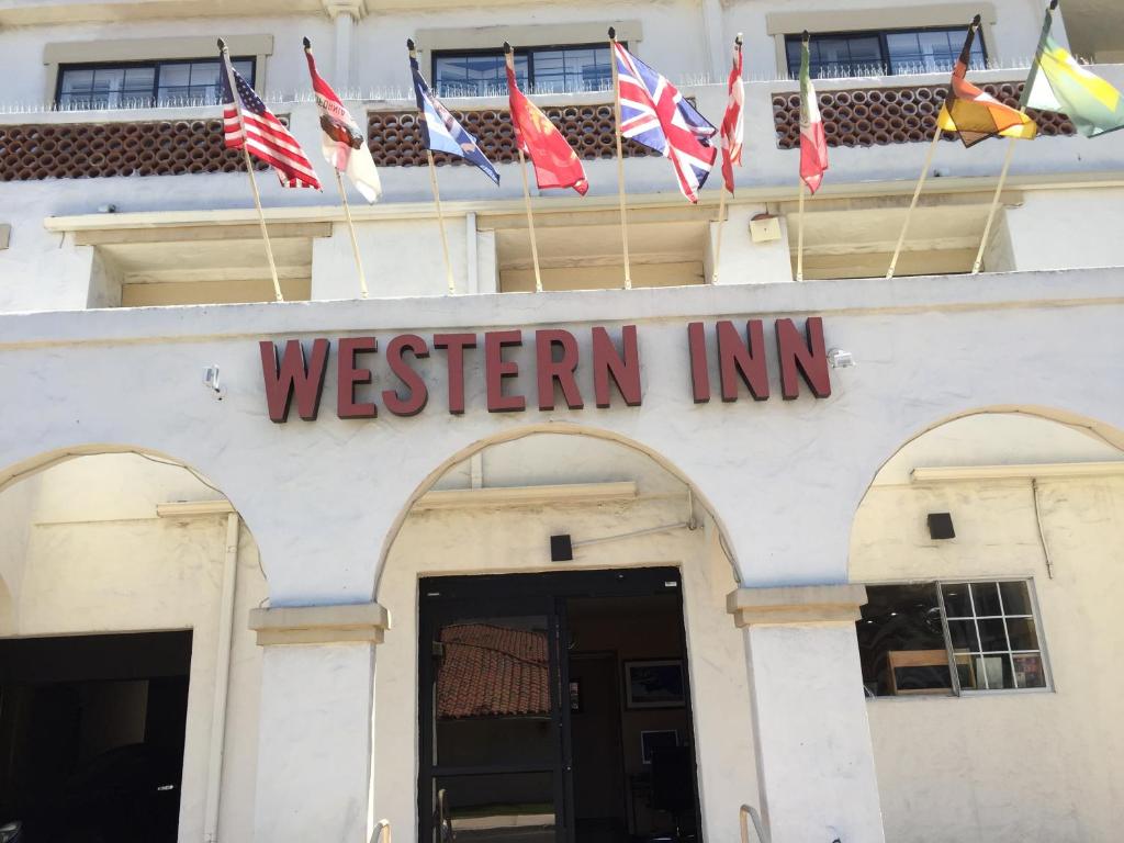 budynek z znakiem, który czyta zachodni zajazd z flagami w obiekcie Old Town Western Inn w mieście San Diego