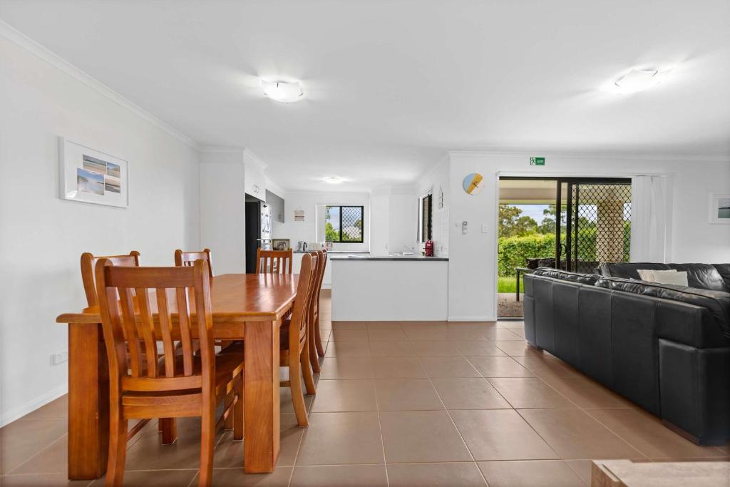 a dining room and living room with a table and chairs at Charming 3-Bed Home Near Sunshine Coast in Caloundra West