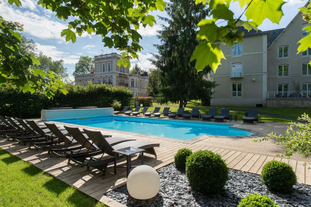 a swimming pool with lounge chairs and a building at Chateau du Clos de la Ribaudiere - Teritoria in Chasseneuil-du-Poitou