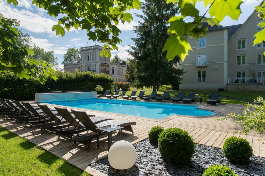 una piscina con tumbonas y un edificio en Chateau du Clos de la Ribaudiere - Teritoria, en Chasseneuil-du-Poitou