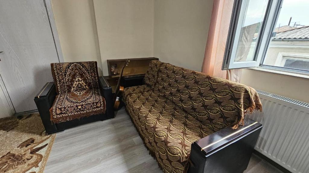 een woonkamer met een bank en een stoel bij Khatuna Home in Tskaltubo