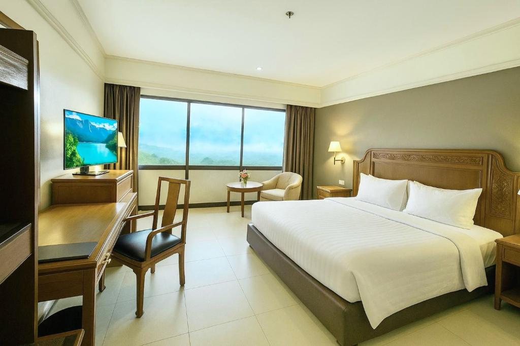 a hotel room with a bed and a desk at Loei Palace Hotel in Loei