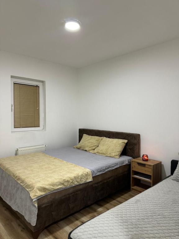 een slaapkamer met twee bedden en een raam bij DP Lux apartman Obrenovac,sa parkingom in Obrenovac