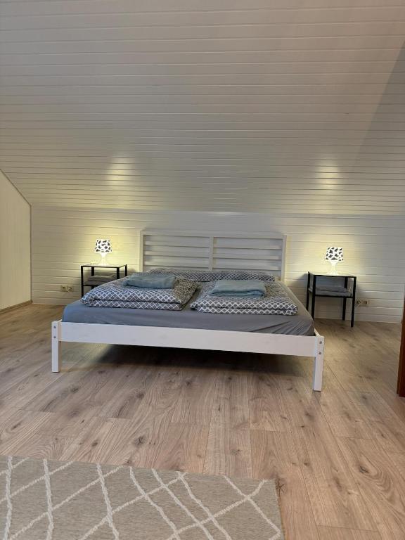 a white bed in a room with two tables at Gemütliche 2,5 Zimmer Wohnung in Grenzach-Wyhlen