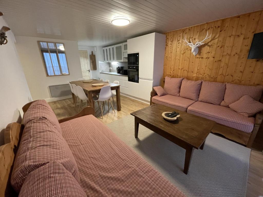 ein Wohnzimmer mit Sofa und Tisch in der Unterkunft Chaleureux appartement Altitude 1500 in Le Lioran