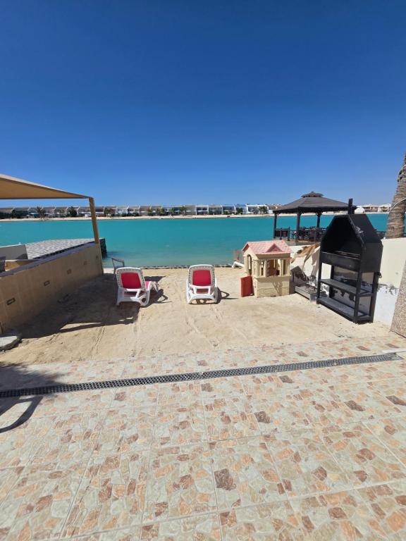 a patio with two chairs and the ocean in the background at فيلا السعادة بيتش درة العروس رملي وخاص in Durat  Alarous