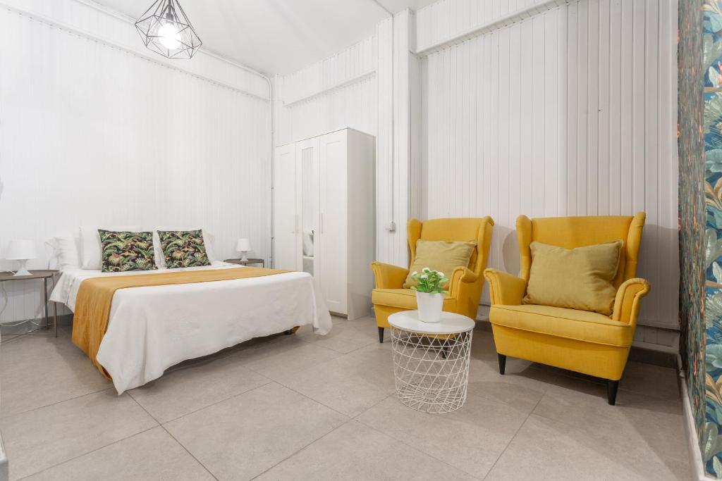 ein Schlafzimmer mit zwei gelben Stühlen und einem Bett in der Unterkunft Estudio Céntrico Santa Cruz in Santa Cruz de Tenerife