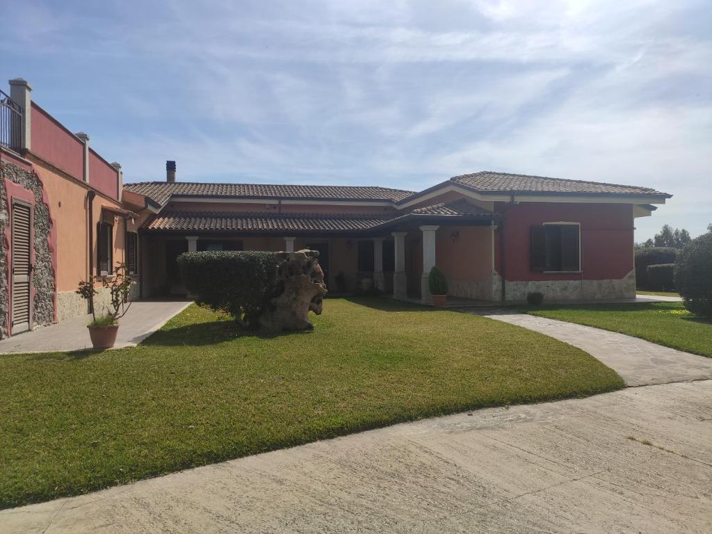 a house with a lawn in front of it at Le sei palme B&B in Terralba