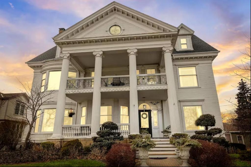 a large white house with a clock on it at Gorgeous Historical Mansion on the Lake Front in Racine