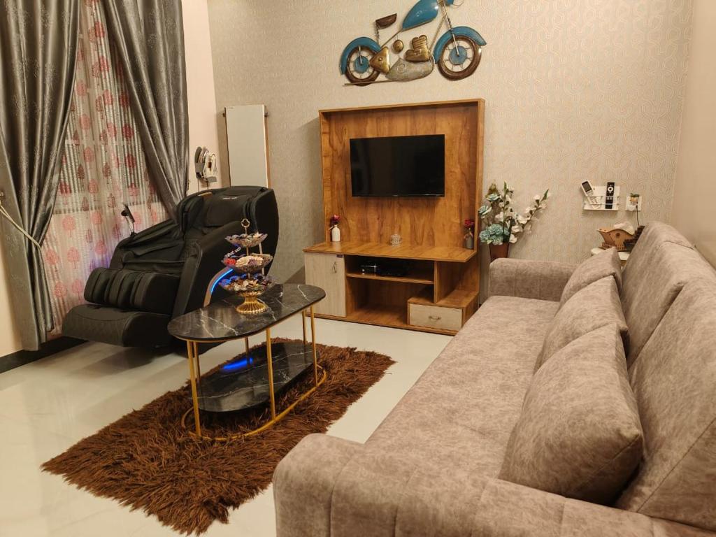 a living room with a couch and a tv at UDUPI HOMESTAY CHALET LA BONNE Vie in Udupi