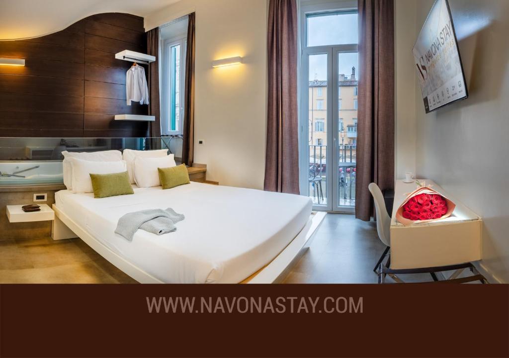 Un dormitorio con una cama blanca grande y una ventana en Navona Stay, en Roma