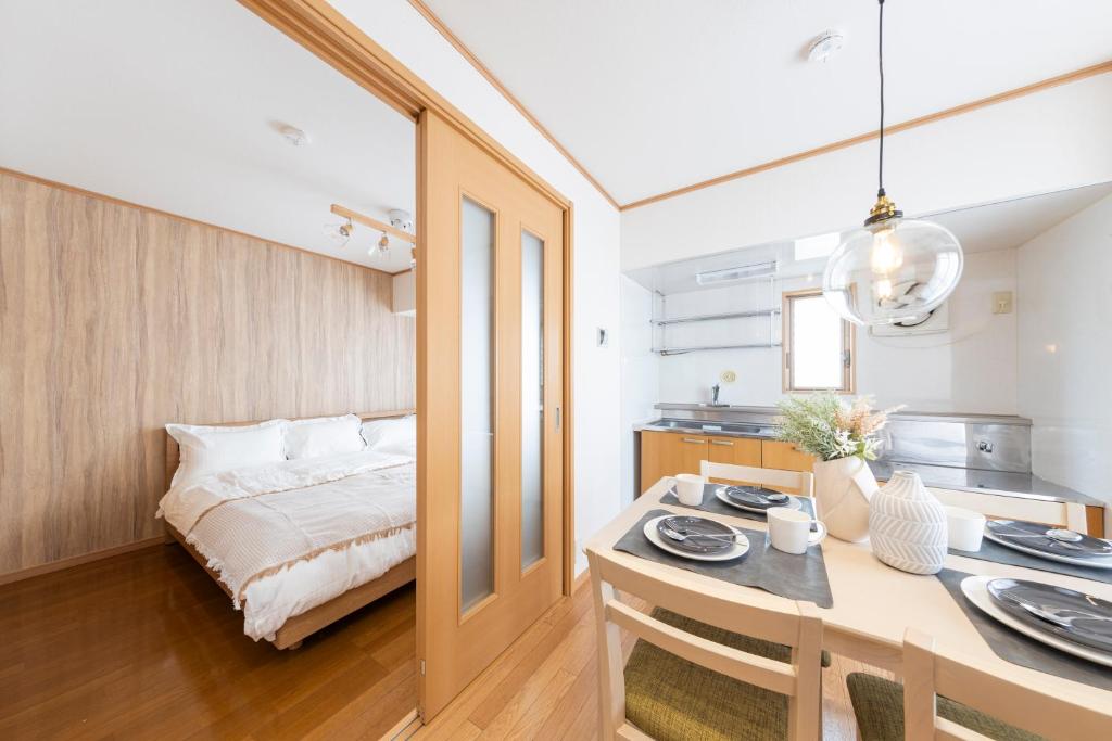 a bedroom with a bed and a table with plates on it at Ayame Building in Tokyo