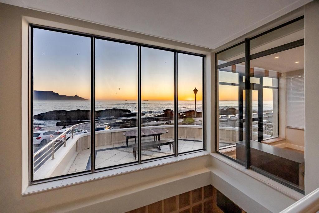 a room with windows with a view of the ocean at HOME-LYNN, 4 bedroom, Bloubergstrand in Bloubergstrand