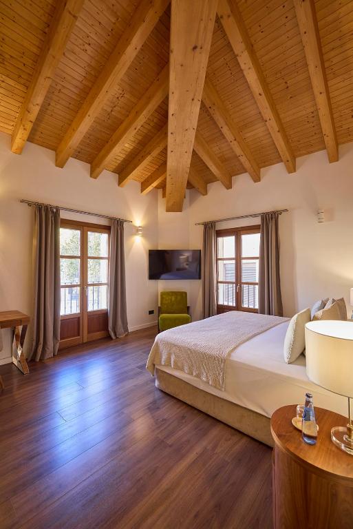 a bedroom with a large bed and wooden ceilings at Hotel Bosch Boutique in Palma de Mallorca