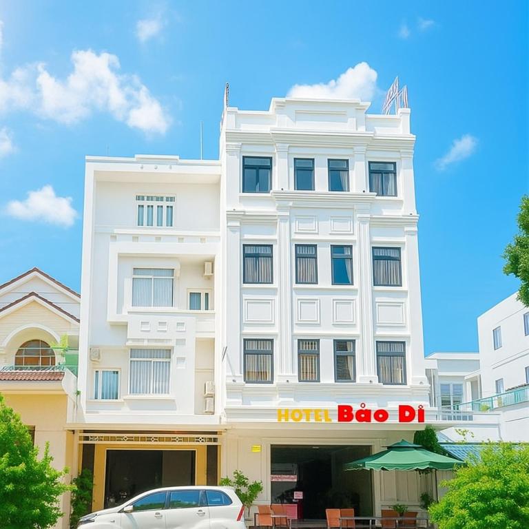 a white building with a car parked in front of it at Bảo Di Sóc Trăng Hotel in Soc Trang